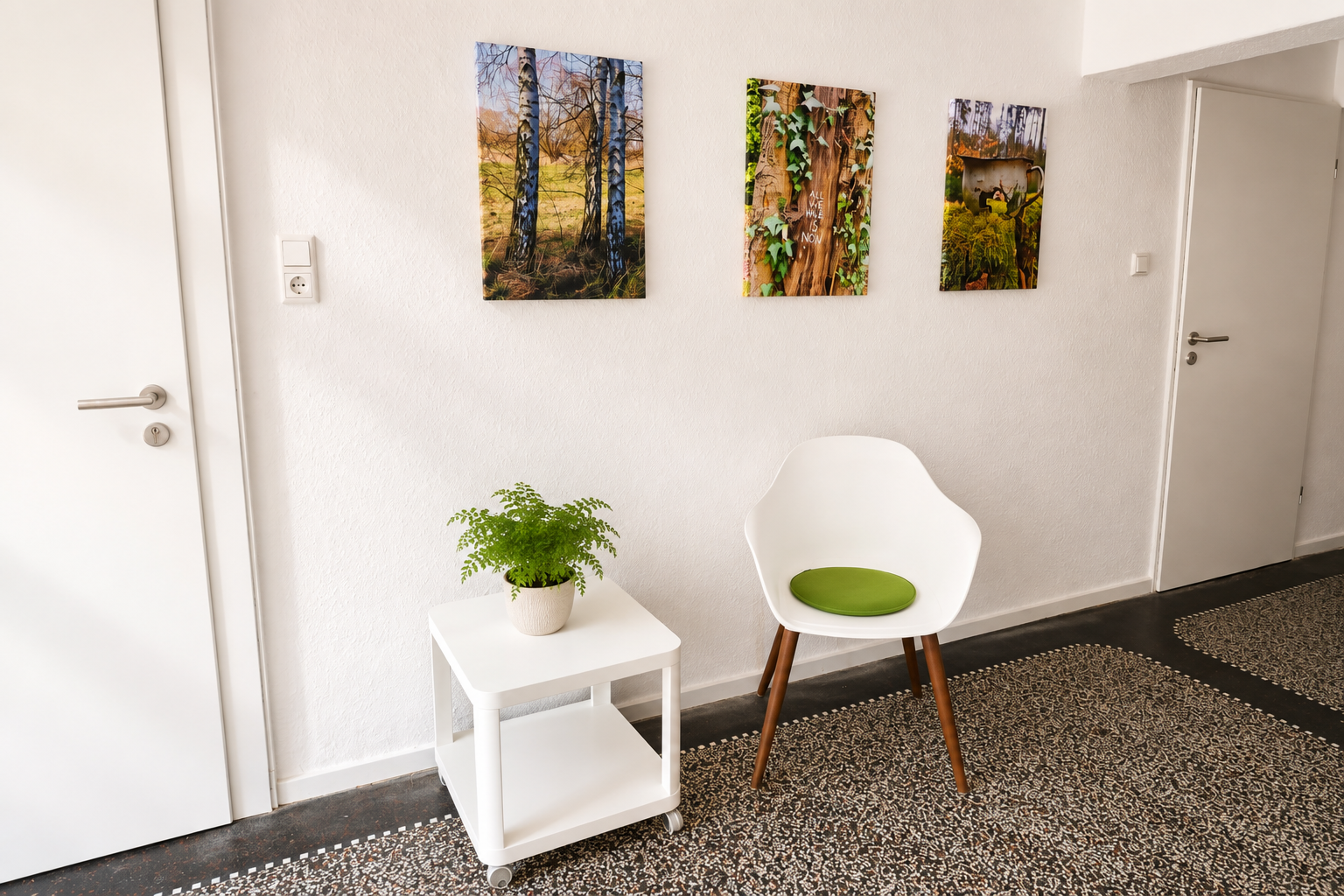 Wartebereich mit Naturbildern, Terrazzoboden und grünem Sitzkissen
